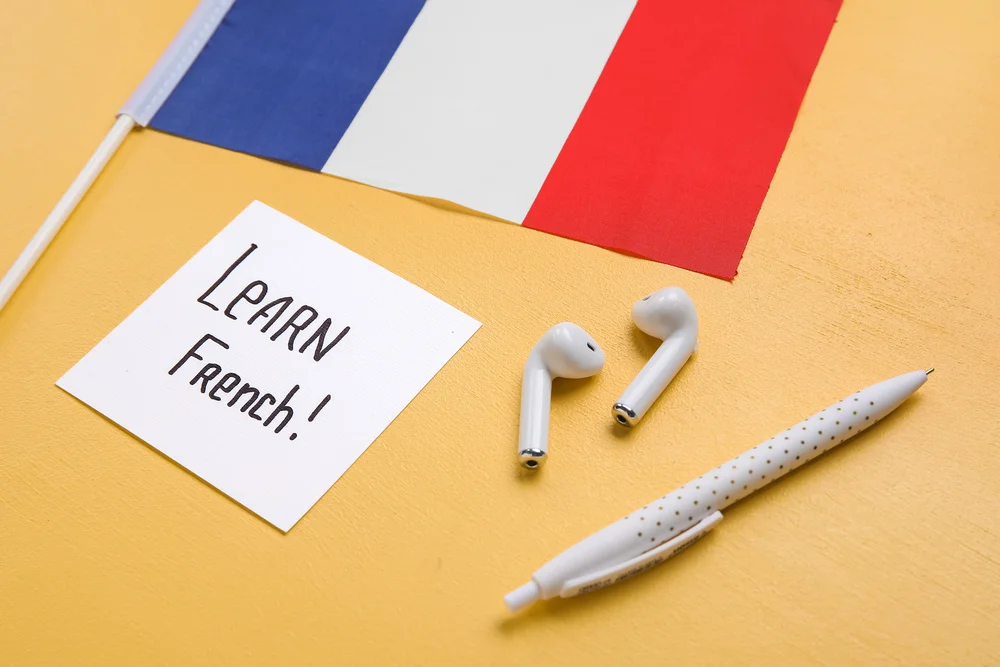 Learn French: Note, French flag, earbuds, pen