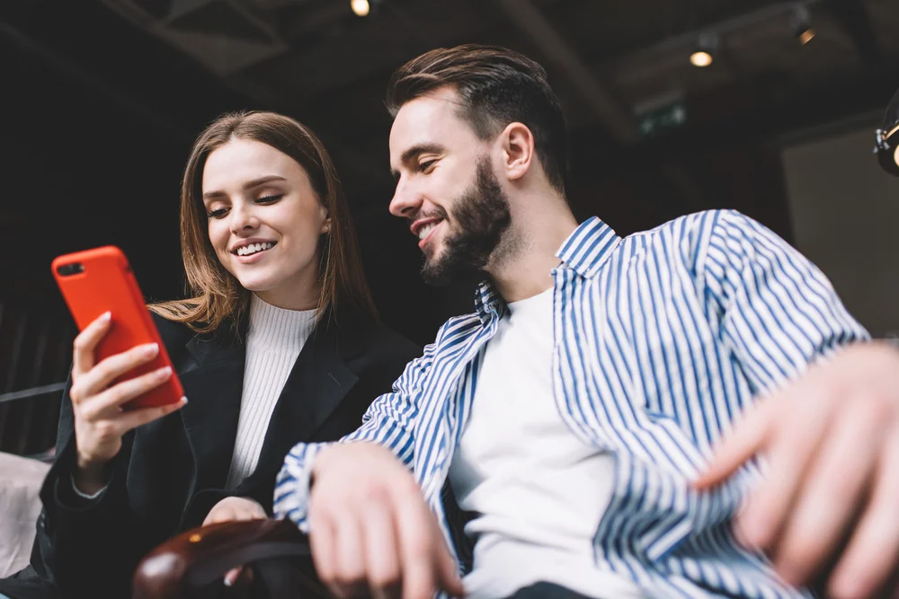 Couple looking at a red smartphone together